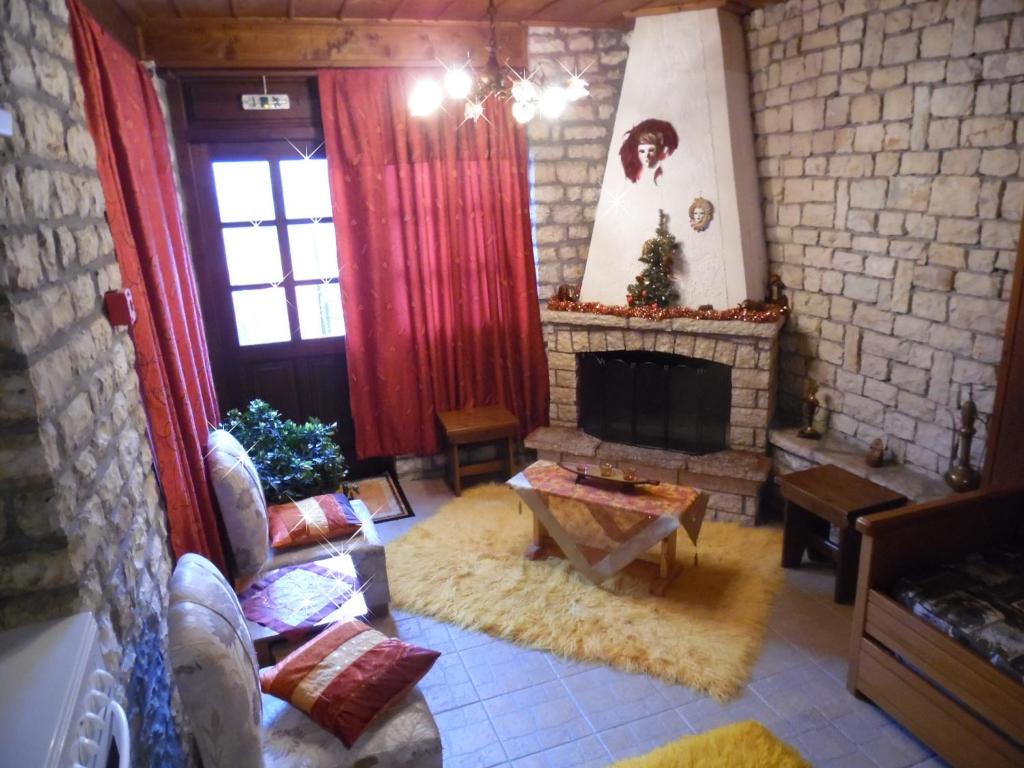 米克隆科利奥Elatos Rooms的客厅设有壁炉和红色窗帘