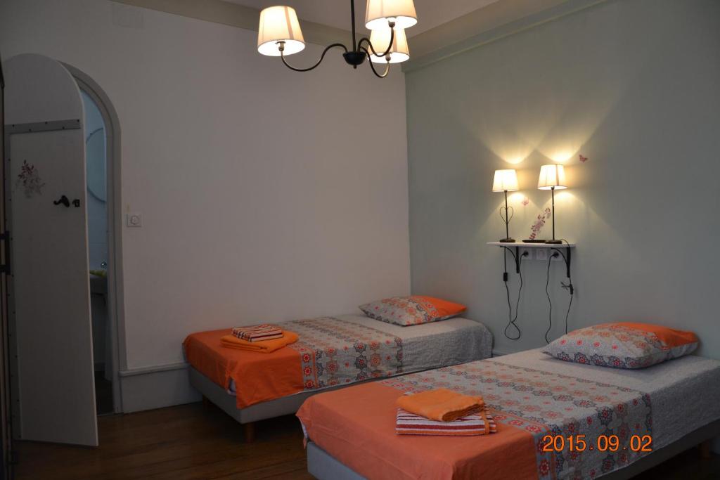 卢尔德麦尔埃尔维拉酒店的一间卧室配有两张床和吊灯。