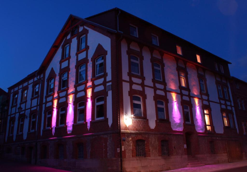 波彭豪森太阳24/7旅馆的建筑的侧面有粉红色的灯