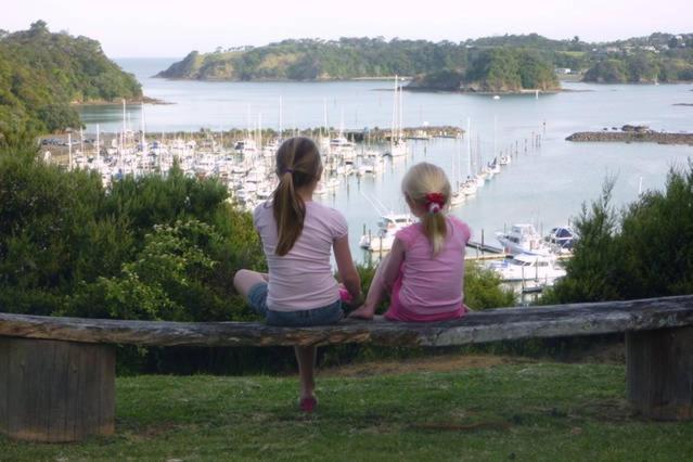 图图卡卡马林瑞吉住宿加早餐旅馆的两个女孩坐在长凳上看着港口