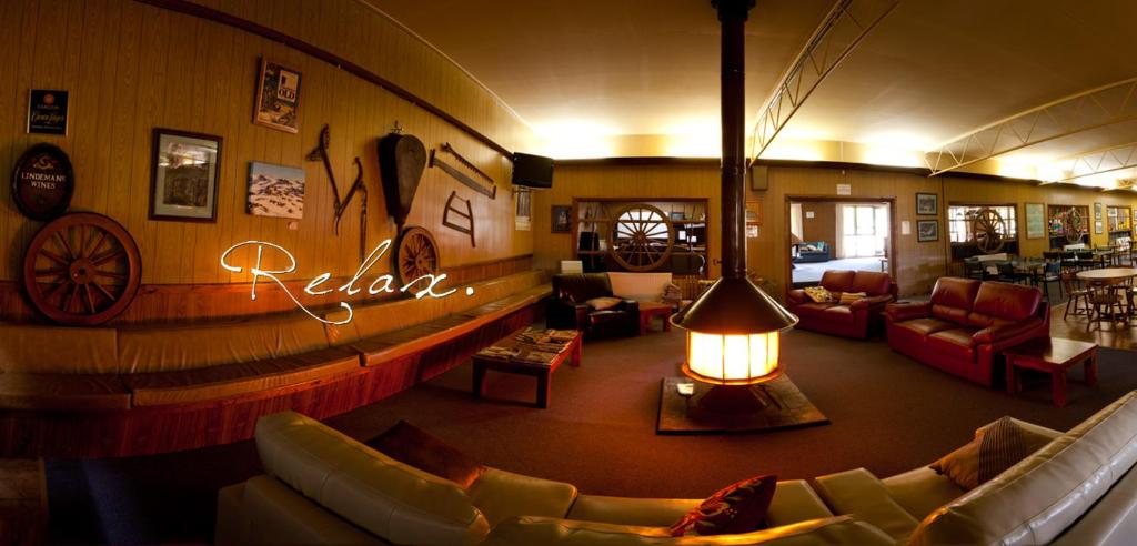 阿达米纳比雪山度假酒店和功能中心汽车旅馆的带沙发的客厅和可供客人放松身心的标志