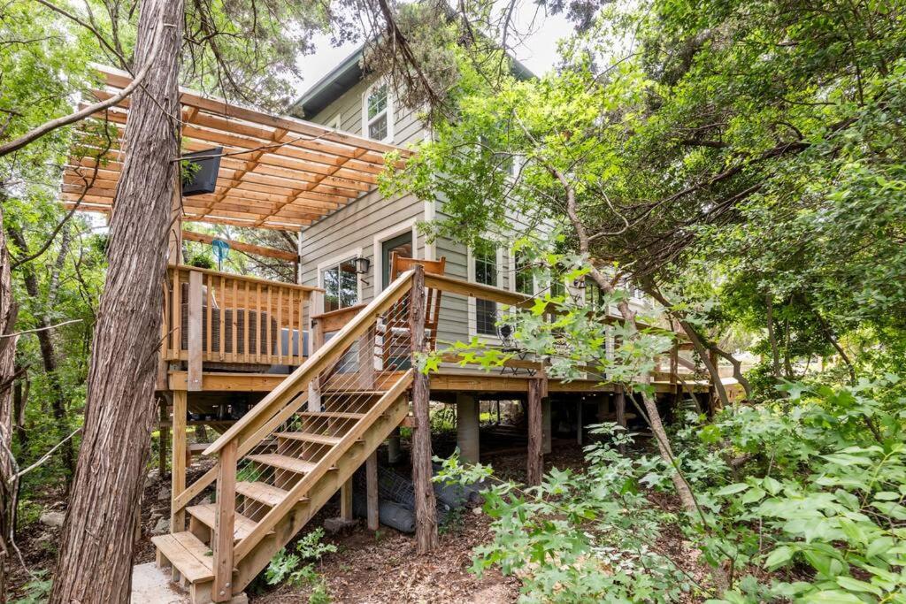 奥斯汀Cozy Coop Casita - Lake Travis-Hot Tub-Tiny House的树林中的房屋,设有木甲板