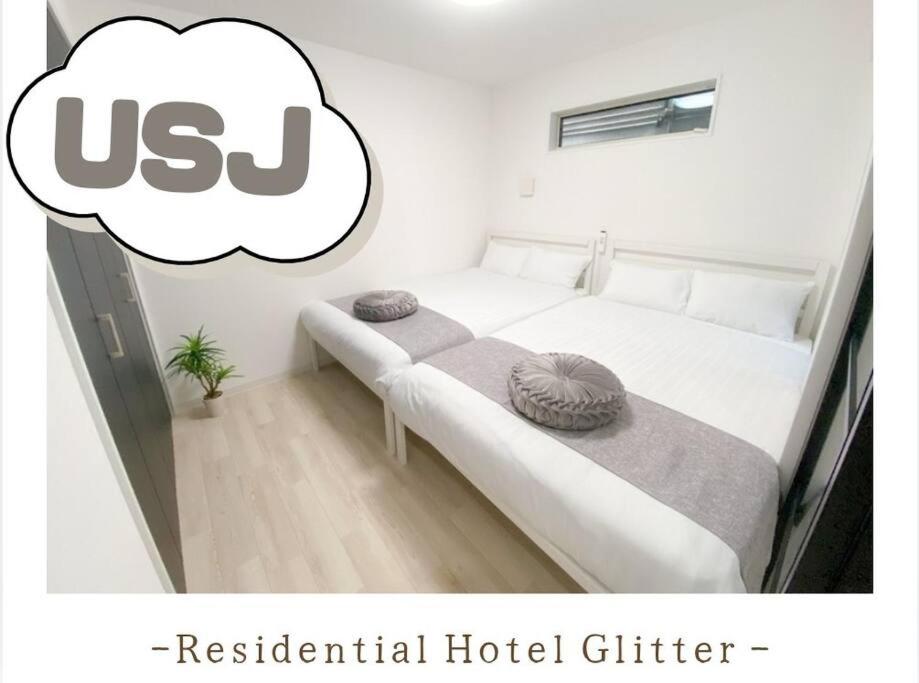 大阪Residential Hotel Glitter USJまで1駅5分的卧室配有一张白色床,带有泡泡