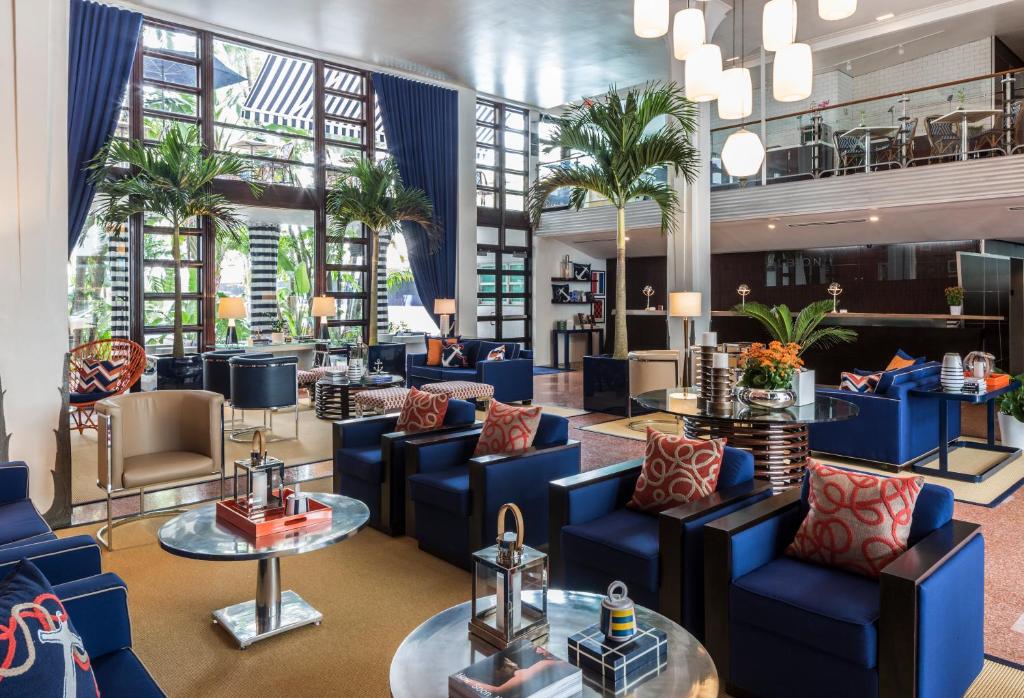 迈阿密海滩阿尔比恩酒店的大堂设有蓝色的桌椅和棕榈树