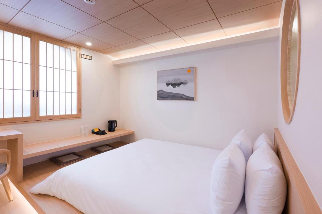 昌原市Hotel Yusurim的一间带床和窗户的白色卧室