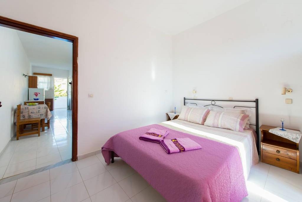 克雷马斯蒂乐居公寓的一间卧室配有一张带粉色毯子的大床