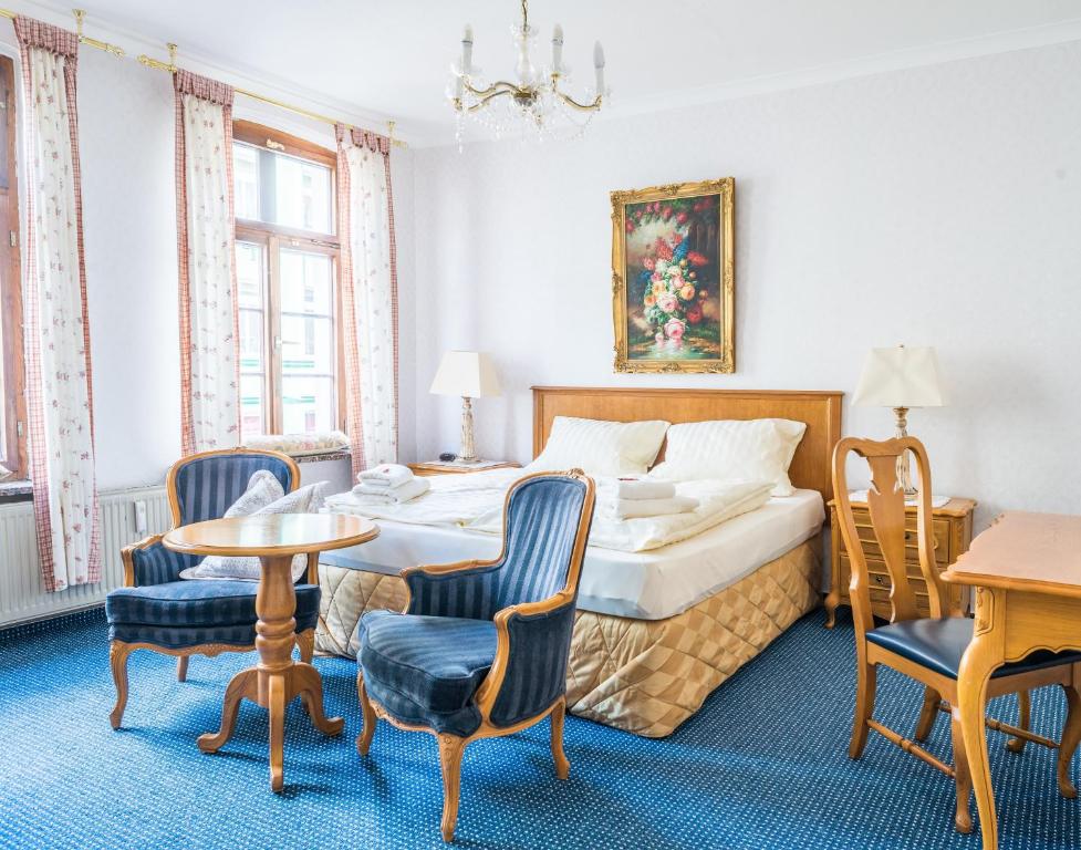 什未林罗曼蒂克祖尔特劳贝施威林酒店的酒店客房带一张床、一张桌子和椅子