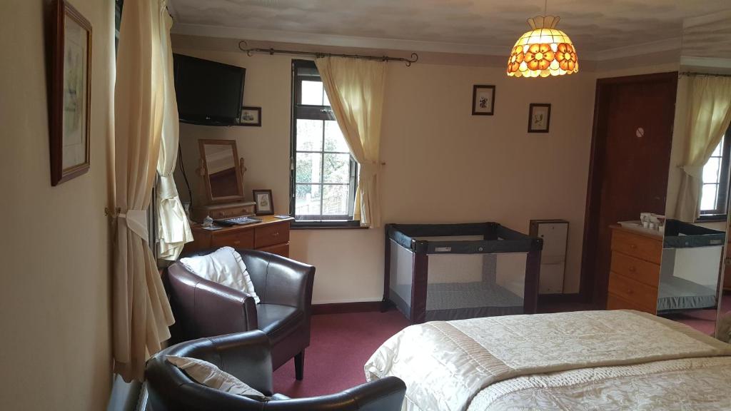 塔维斯托克Kingfisher Cottage的卧室配有一张床、一张桌子和椅子