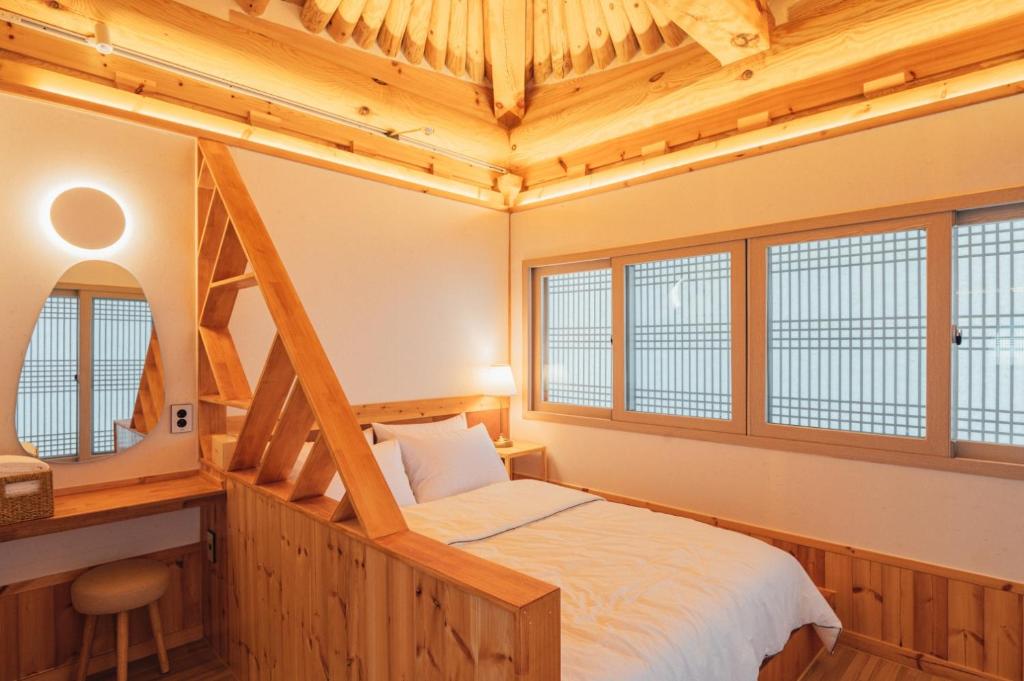 庆州Hanok Stay Seowa的带床、书桌和窗户的卧室