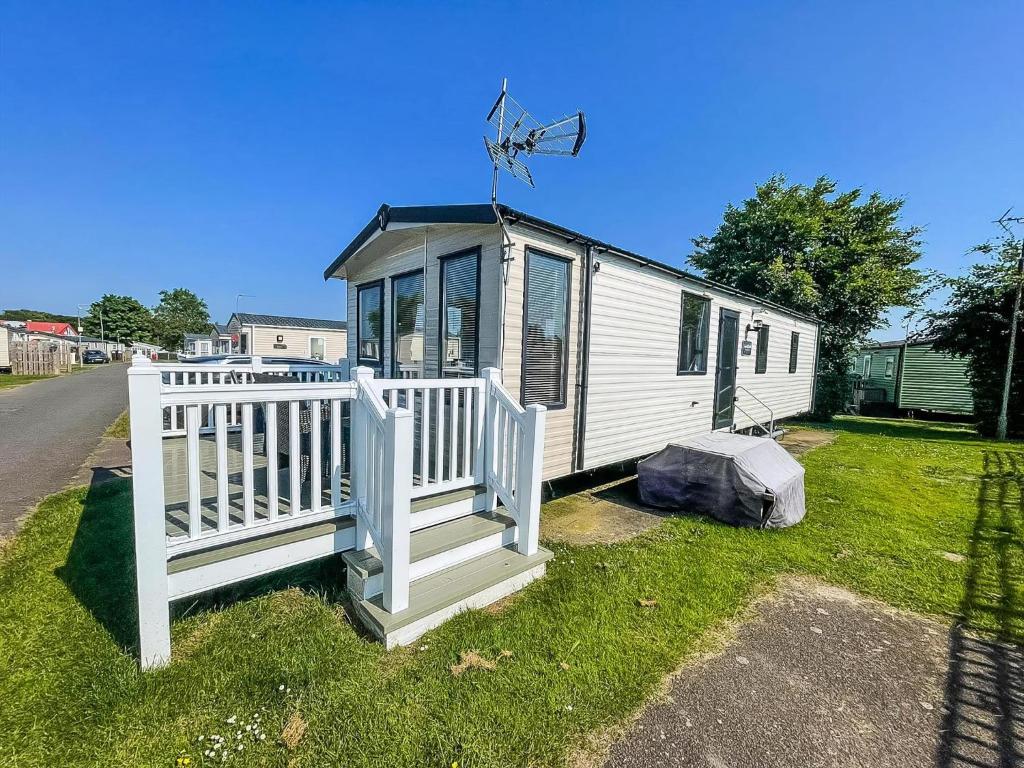 大雅茅斯Lovely 6 Berth Caravan With Decking At Cherry Tree Park In Norfolk Ref 70320C的白色的小房子,有白色的围栏