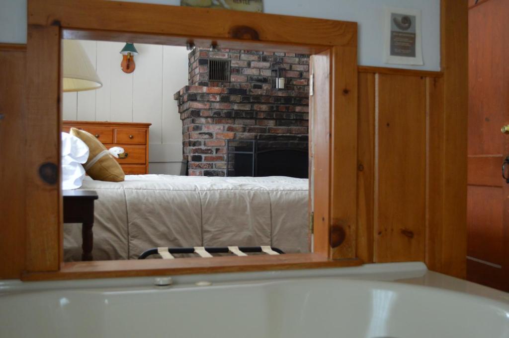 泊鲁威利宾馆的一间带壁炉的浴室和一张位于客房内的床