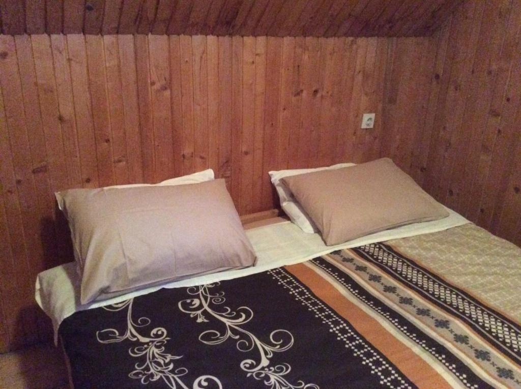 扎布利亚克Holiday Home Stevas的木墙客房的一张带两个枕头的床