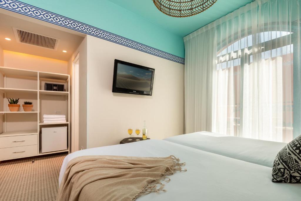 埃拉特U Splash Resort Eilat的一间卧室，墙上有一张床和一台电视