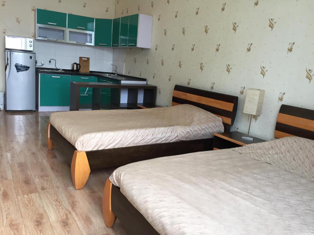 乌兰巴托特索蒙斯服务式公寓的客房设有两张床和带冰箱的厨房