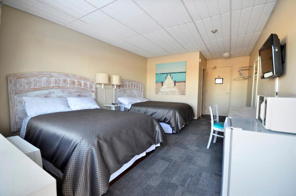 温尼伯圣诺伯特酒店的酒店客房设有两张床和一张桌子。