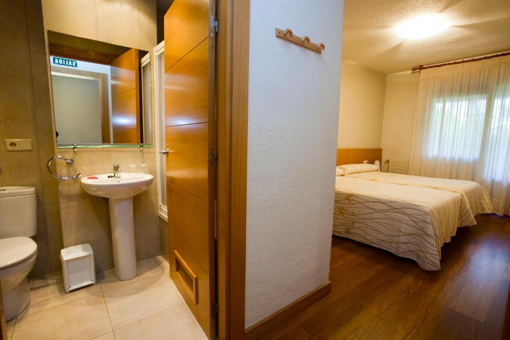 潘普洛纳阿博蒂旅馆的一间带床、水槽和卫生间的浴室