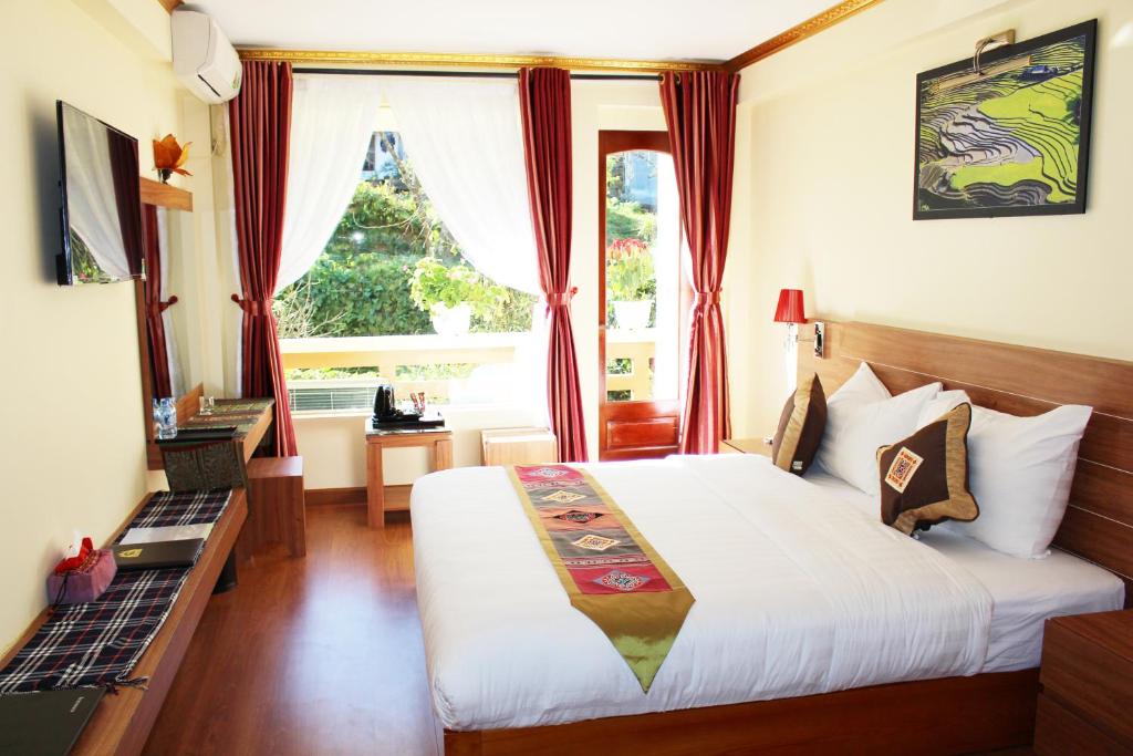 萨帕萨帕黄龙酒店的酒店客房设有床和窗户。