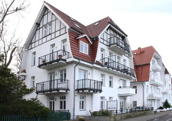 瓦尔内明德Ferienwohnung Warnemünde L (S2)的一座大型白色建筑,其侧面设有阳台