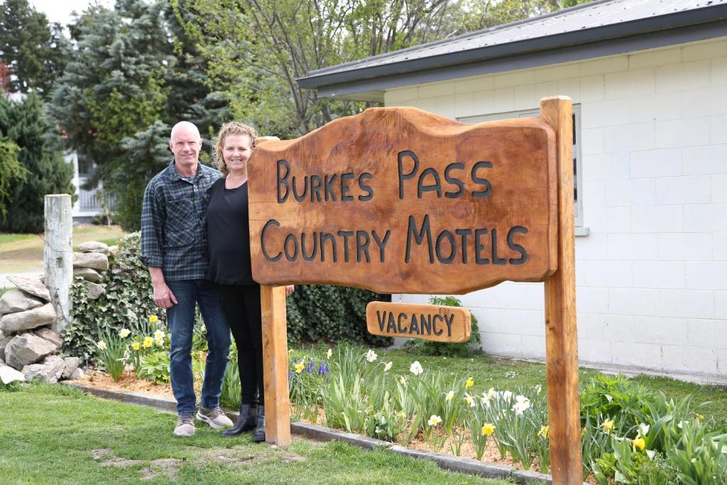 伯克斯帕斯Burkes Pass Country Motels的站在标志旁的男人和女人