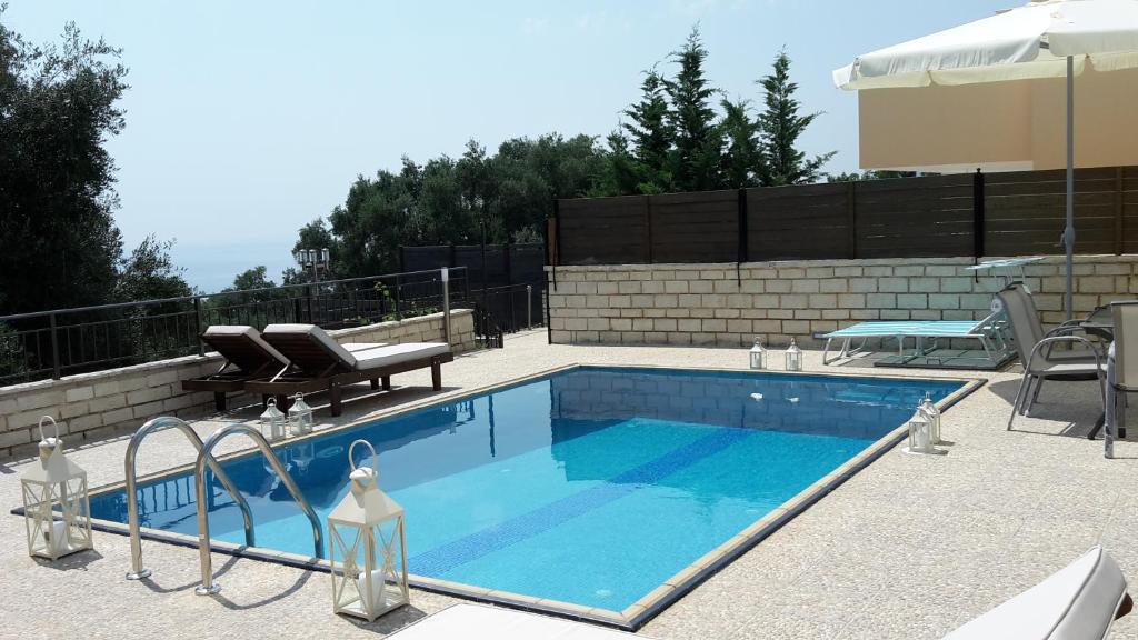 帕拉马Achillion Luxury Corfu Villa的一个带两把椅子和一张桌子的游泳池
