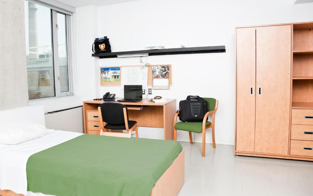 多伦多多伦多大学新学院45威科克斯公寓酒店的一间卧室配有一张床和一张带电脑的书桌