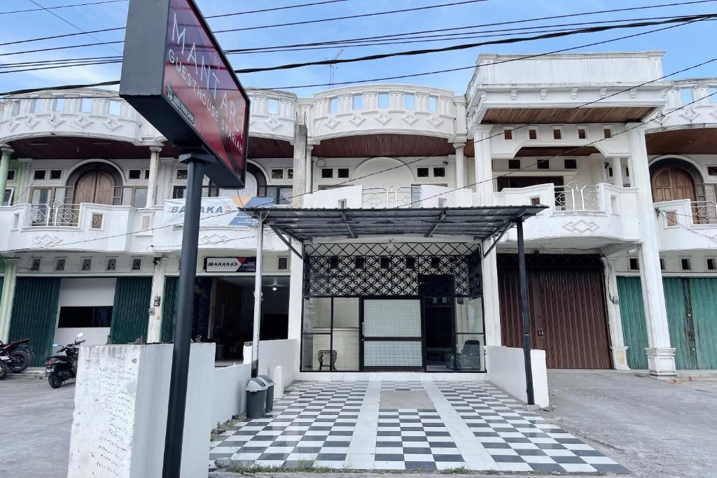 武吉丁宜OYO 94343 Mantari Guesthouse的前面有标志的建筑