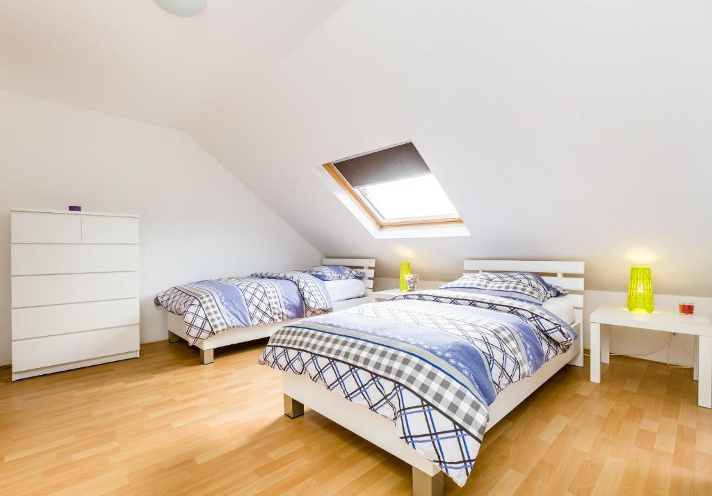 门兴格拉德巴赫Apartments Mönchengladbach的阁楼卧室设有两张床和天窗