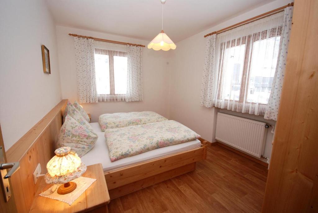 圣坎迪朵Appartments Oberhofer的卧室配有床、桌子和窗户。