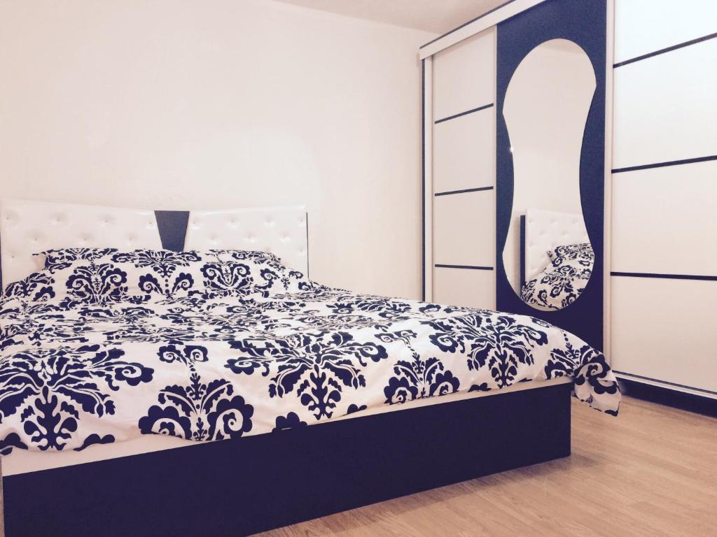 普里什蒂纳塔夫的小房子公寓的卧室配有黑白床和梳妆台。