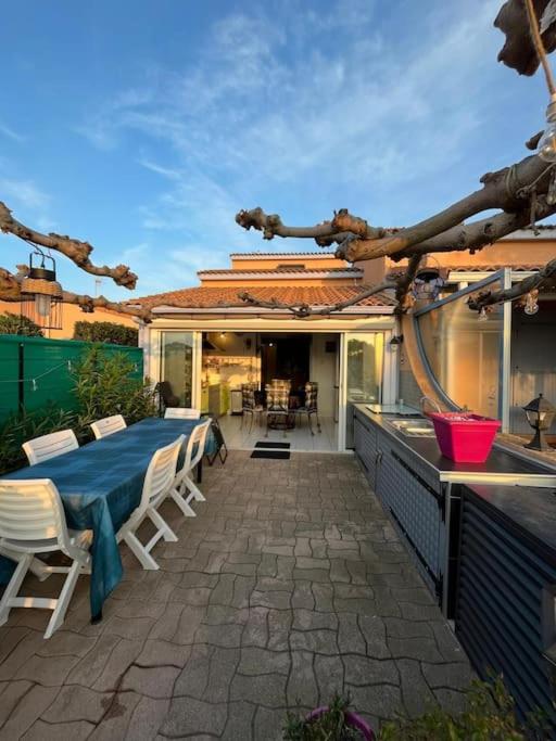 乐巴凯尔斯Maison au bord de l&#39;etang的一个带桌椅的庭院和一间厨房
