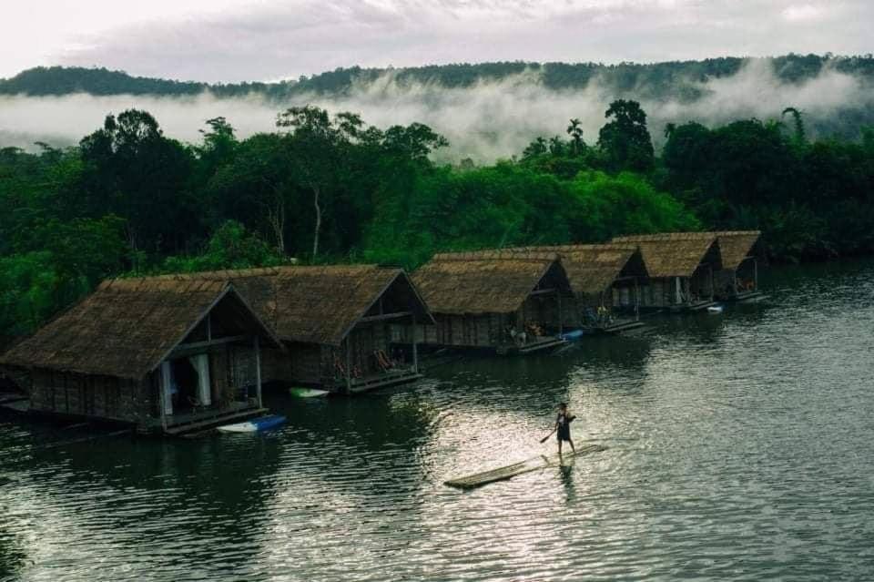 TataiThansur Tatai Eco Resort的站在水中的桨板上的人