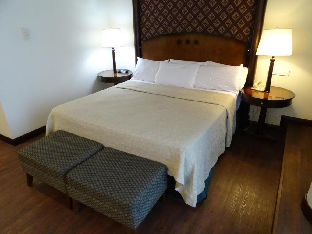 布宜诺斯艾利斯阿巴斯托酒店的酒店客房设有一张大床和两盏灯。