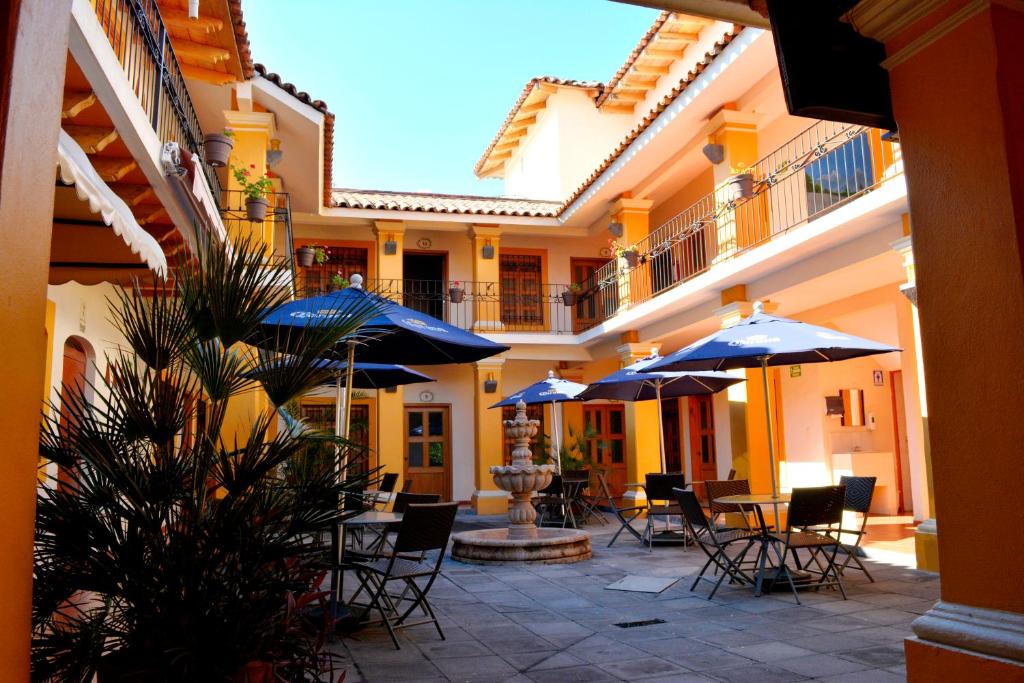 科利马阿尔达马酒店的庭院配有桌椅和遮阳伞。