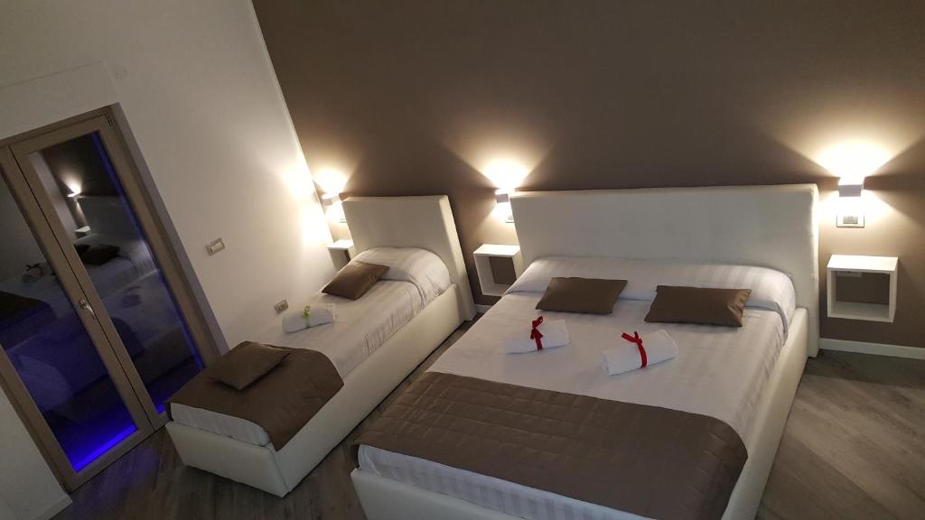 菲乌米奇诺拉里拉住宿加早餐旅馆的一间小卧室,配有两张床和镜子