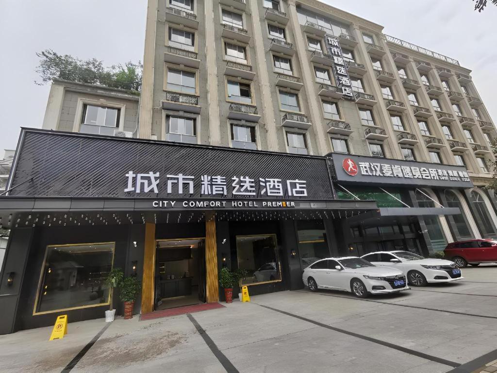 武汉Premier City Comfort Hotel Wuhan Hankou Railway Station Changgang Road Metro Station的城市酒店门前设有停车场