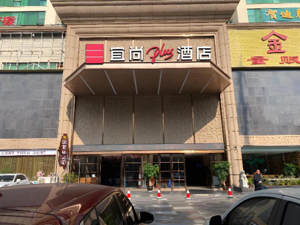 南宁Echarm Plus Hotel Nanning Convention and Exhibition Center Medical University的前面有橙色锥形的建筑