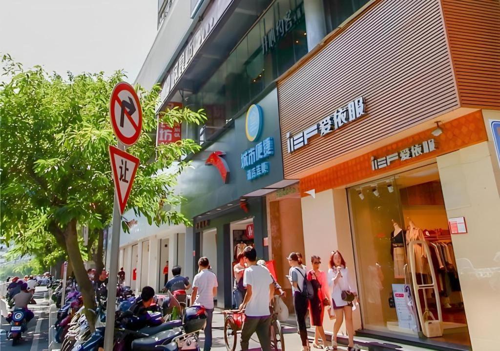 海口City Comfort Inn Haikou Zhongjie Road Walking Street的一群人走在商店前的街道上