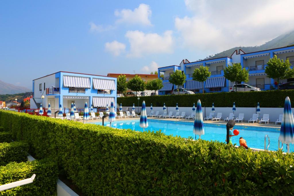 普拉亚·阿马勒Residence Soleluna的一个带蓝色遮阳伞的游泳池的度假酒店