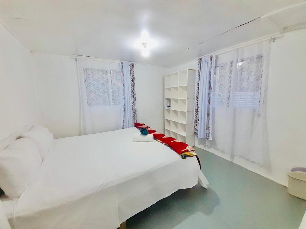 HofoaPrivate Double Room - Tonga Coral Cottage的白色的卧室设有白色的床和窗户。