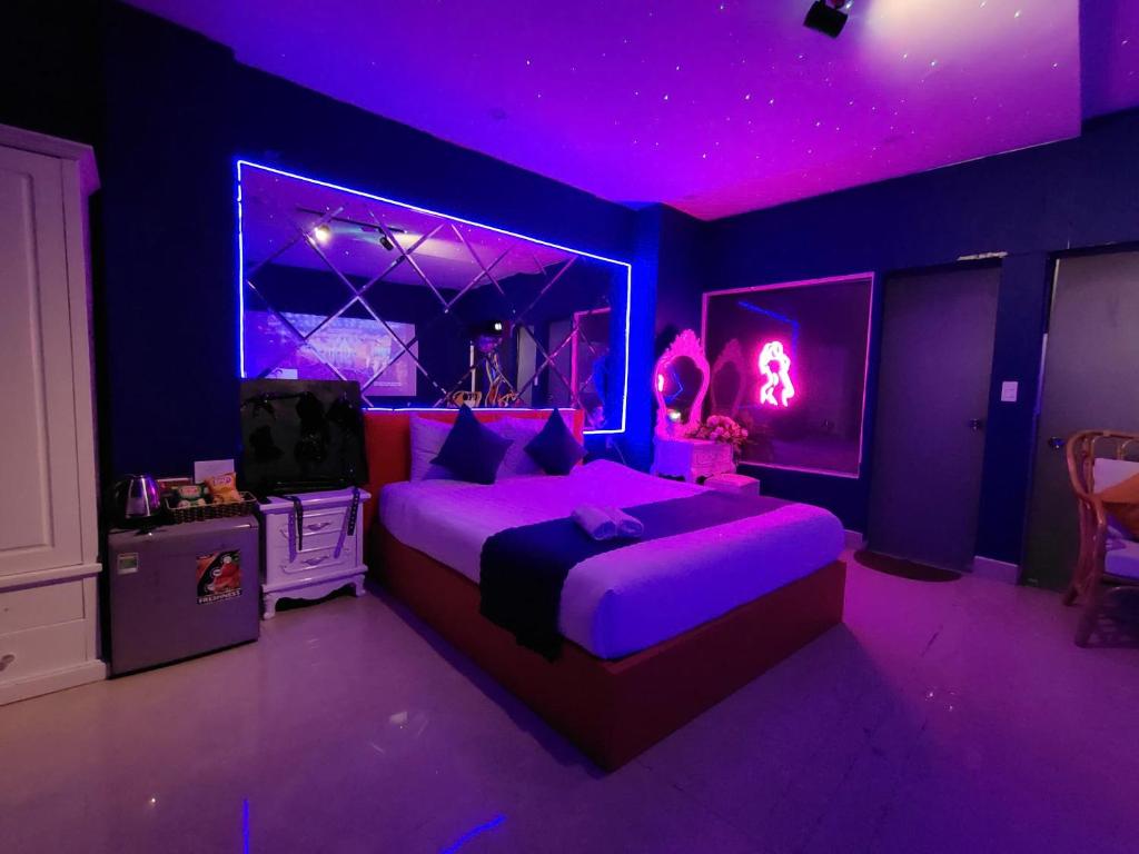 大叻Ngan Pho Studio & Love Hotel的一间紫色卧室,配有一张床和一台电视