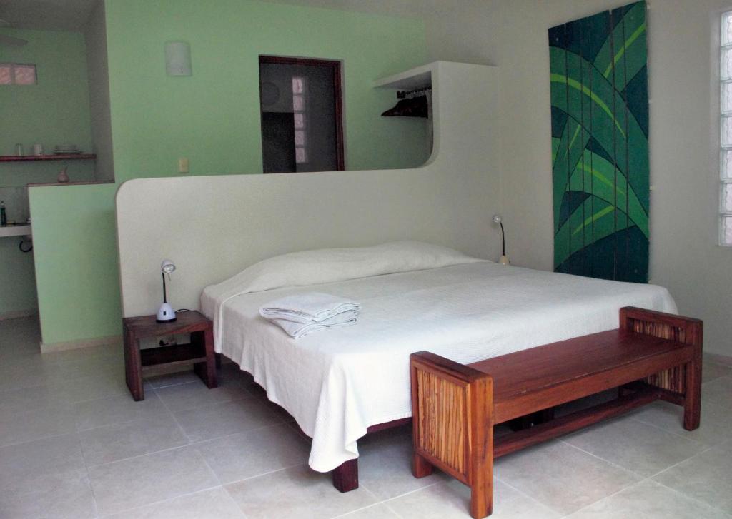 女人岛小岛元素公寓的一间卧室配有一张带长凳和镜子的床