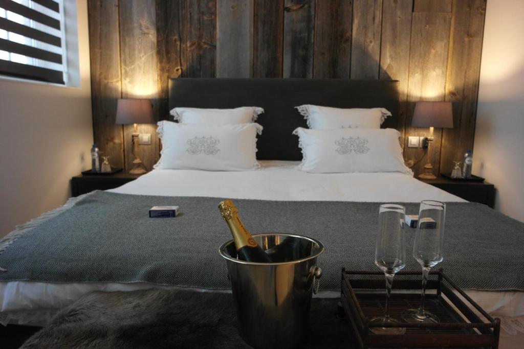 布鲁日16号住宿加早餐旅馆的一张带一瓶香槟和两杯酒的床