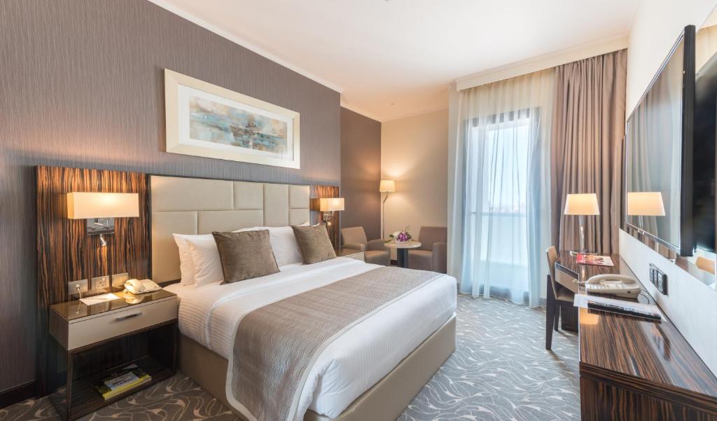 阿布扎比Hawthorn Extended Stay by Wyndham Abu Dhabi City Center的酒店客房设有一张大床和一张书桌。