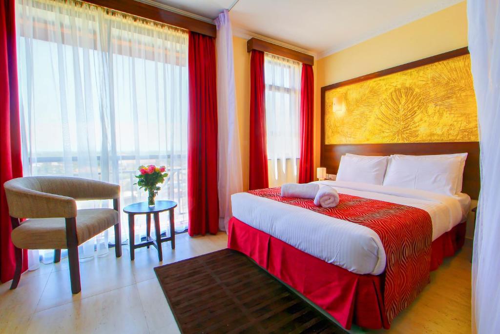 基苏木维多利亚套房酒店的酒店客房带一张大床和一把椅子