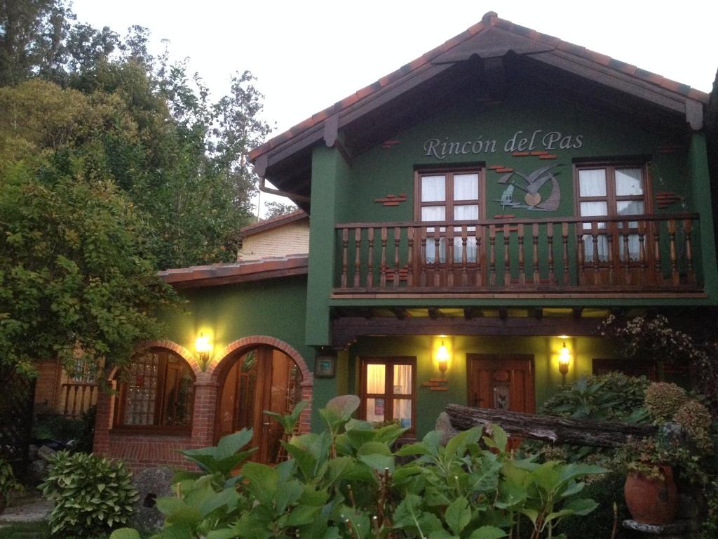 蓬特维耶斯戈波萨达德尔帕斯酒店的一座绿色房子,旁边是钟