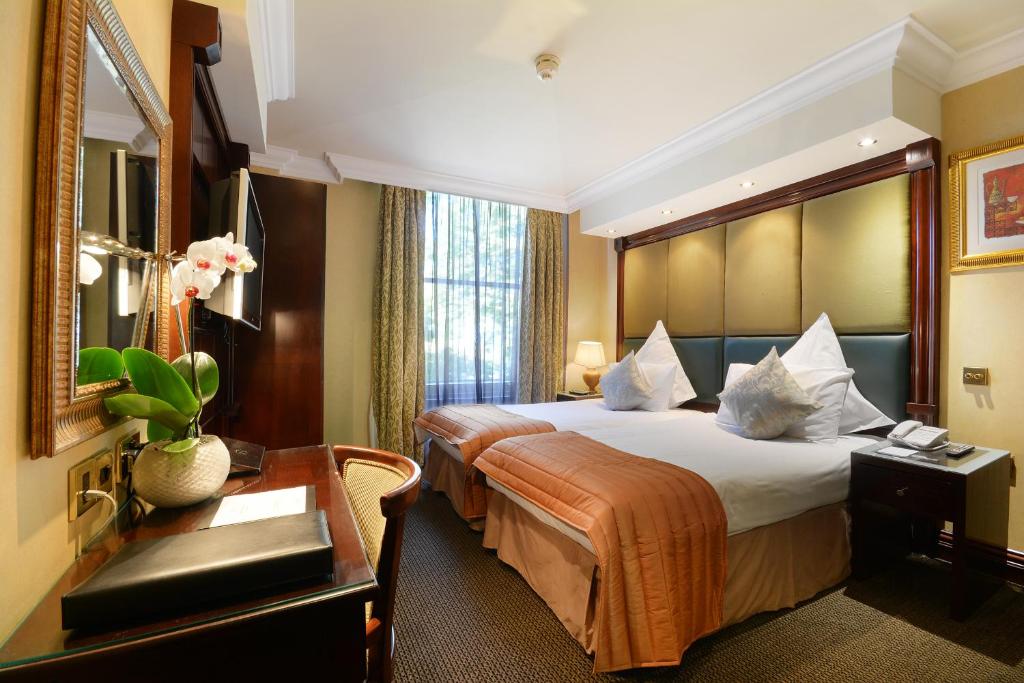 伦敦诺丁山尊贵酒店的酒店客房设有一张大床和一张书桌。