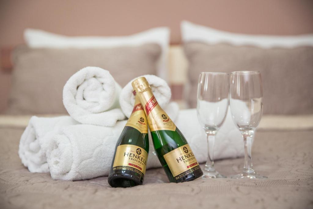 皮罗特Sin-Kom Hotel Garni的桌子上两瓶香槟酒,配有毛巾和酒杯