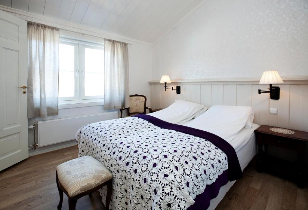 勒罗斯Erzscheidergaarden Hotell的一间卧室设有一张大床和一个窗户。