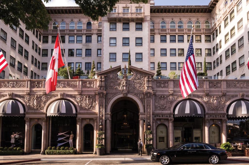 洛杉矶比佛利山威尔希尔酒店（四季酒店集团成员）的停在有旗帜的建筑前面的汽车