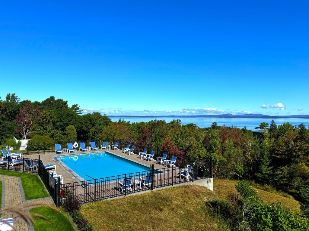 巴港Atlantic Eyrie Lodge的享有带椅子和水的游泳池的空中景致